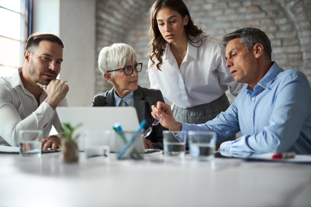 Small business owner meeting with employees and lawyer to discuss estate plan.